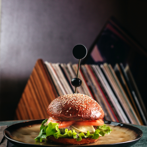 front view hamburger inside round plate dark floor